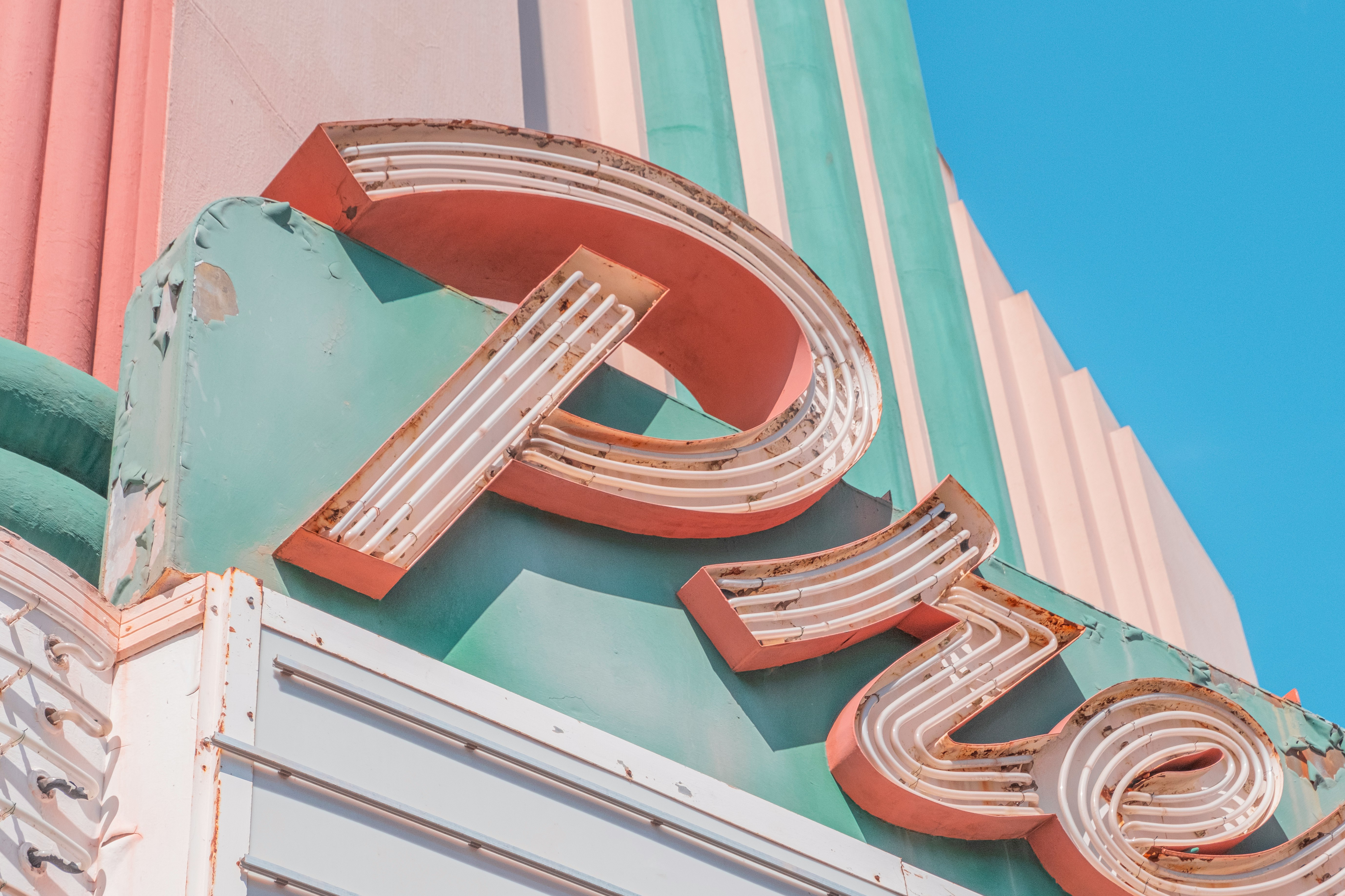 brown and white round frame on teal and pink concrete building